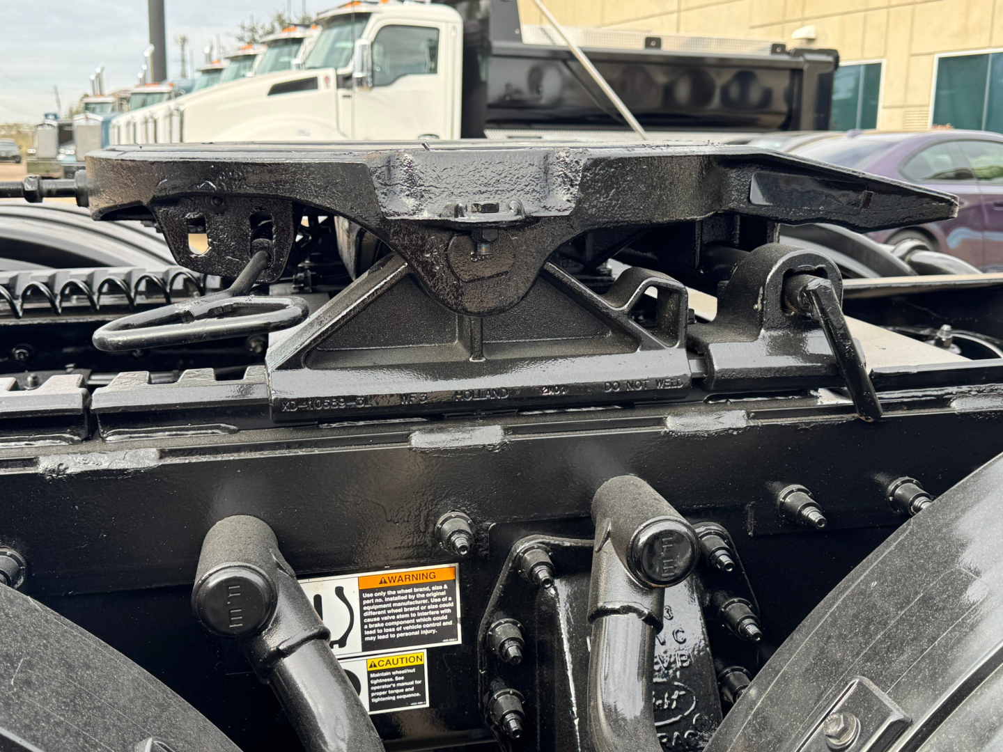 Conventional Daycab tractor frame with mounting hardware and warning labels visible. Text on labels includes small warning and instruction blocks near center.