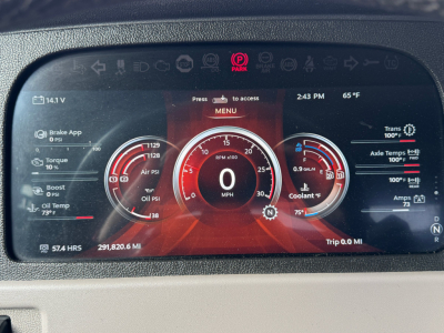 Digital instrument cluster showing vehicle status in red theme. Center dial reads 0 MPH. Surrounding gauges for oil pressure, boost, coolant, and trans temps. Top menu and time 2:43 PM, 65°F. Left shows brake app, torque, oil pressure; rig