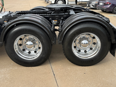 Peterbilt 389 truck rear view showing dual rear axles with polished chrome wheels and black fenders.
