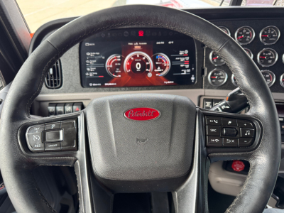 Peterbilt 389 steering wheel and dashboard with digital instrument cluster and controls visible.