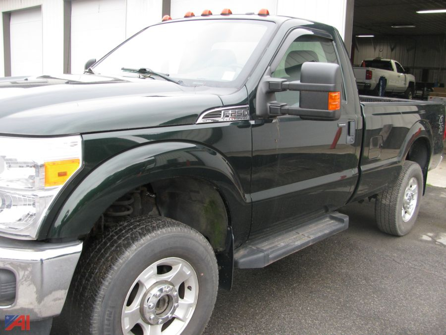 Ford F-250 Super Duty pickup truck with plow, dark green exterior, side steps, tow mirrors, and work truck bed in a dealership lot.