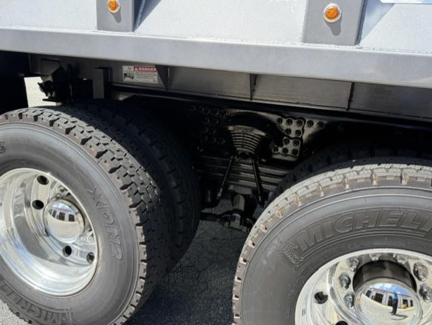 Axle and dual rear wheels of a Western Star 47X dump truck showing heavy-duty suspension and tire treads.
