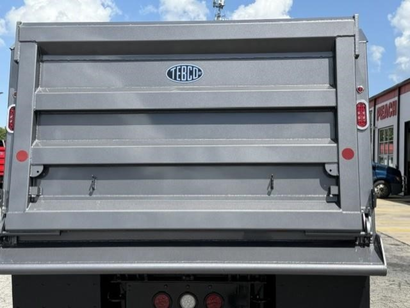 Western Star 47X dump truck bed rear view with TECO logo on tailgate and hydraulic tailgate edge seen.