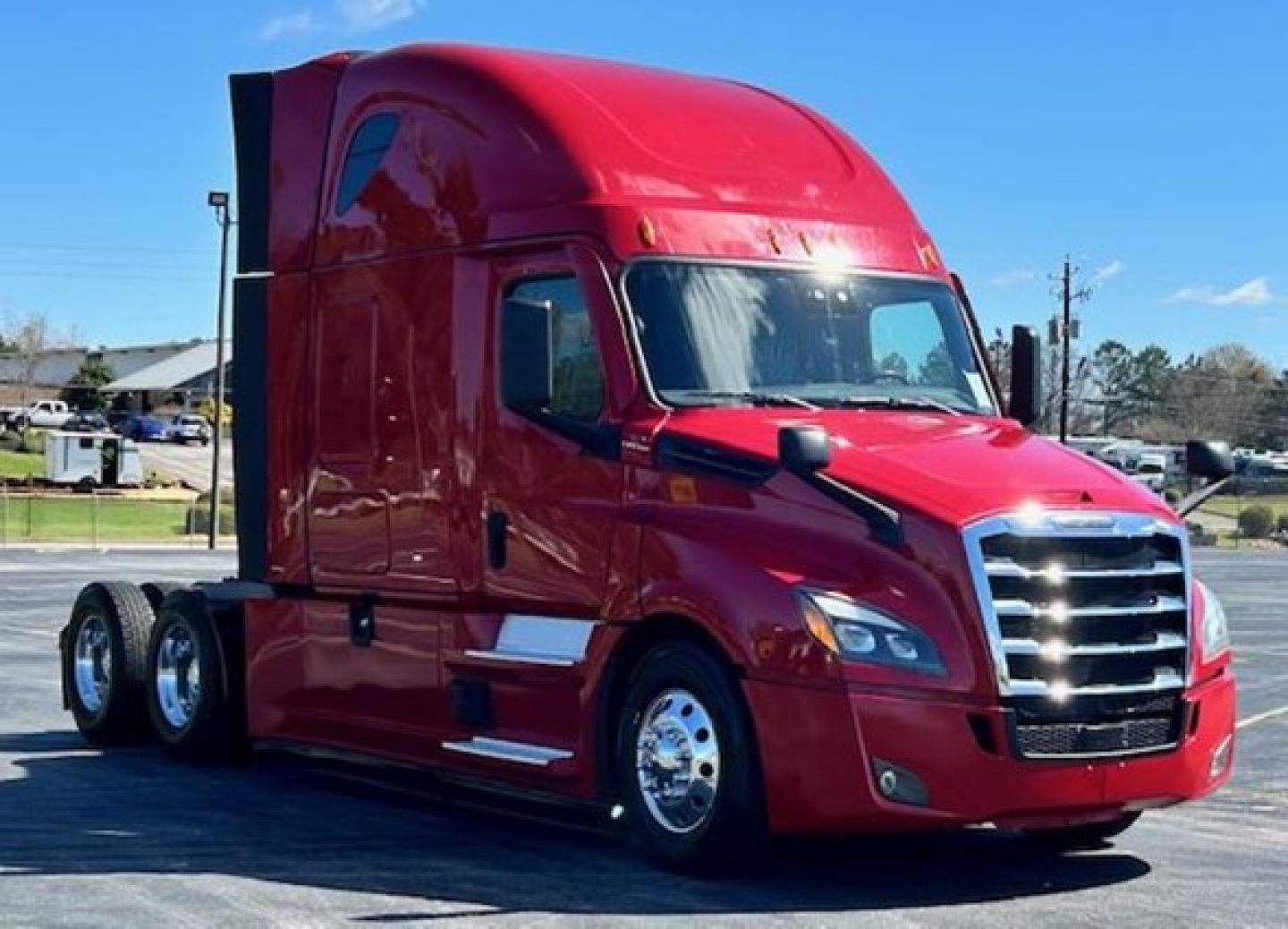 2023 Freightliner Cascadia 126 conventional sleeper truck in red, side view showing cab and front grille.