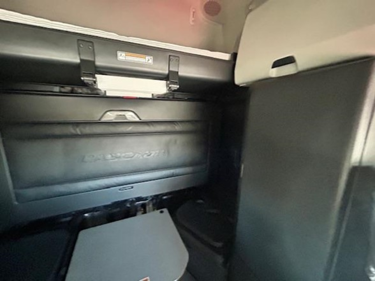 Trunk area of 2023 Freightliner Cascadia 126 sleeper cab showing storage compartments and cargo area lid with embossed Freightliner logo.