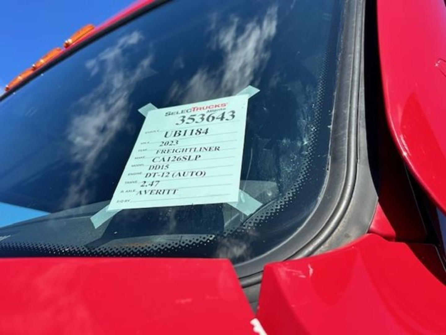 Truck windshield with a sale tag visible on the glass showing stock number 353643 and other identifiers.