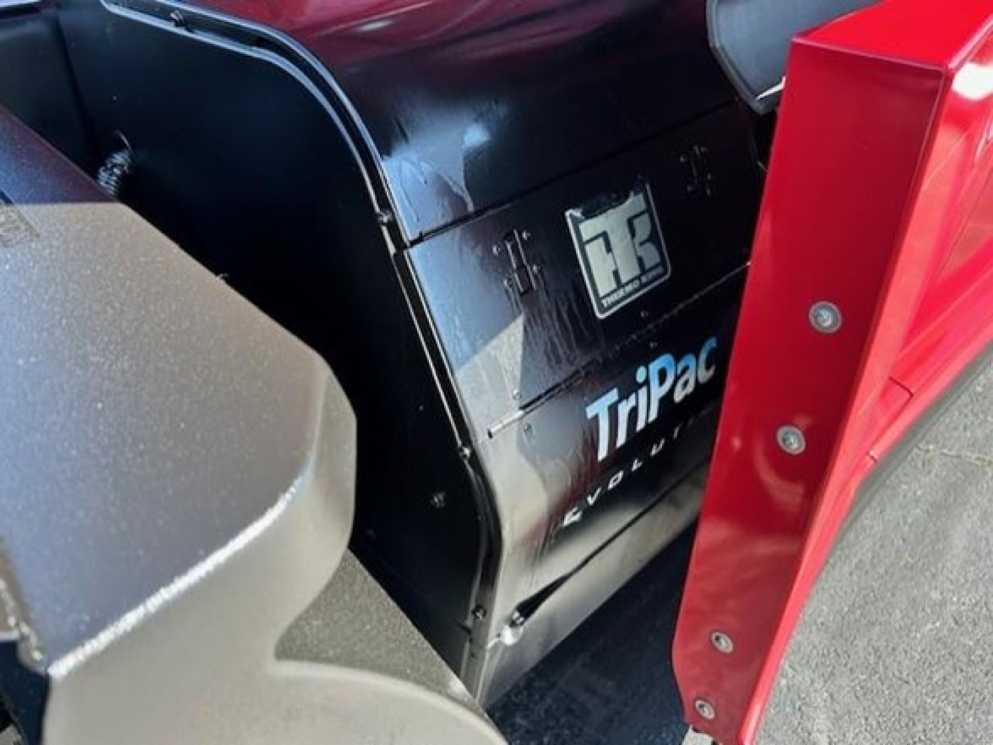 Freightliner Cascadia truck side panel showing Tripac cooling unit and logo, with black exterior and blue white text.