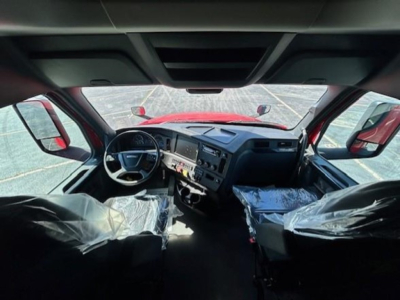 Interior view of Freightliner Cascadia 126 cab showing steering wheel, dashboard, and seating wrapped in plastic.
