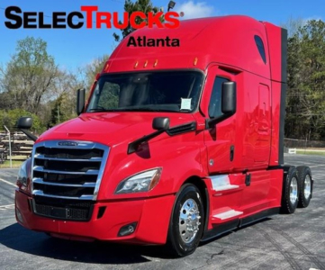 Truck cab showing a bright red Freightliner Cascadia 126 in a dealership lot with SelectTrucks Atlanta logo.