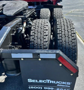 Rear view of Freightliner Cascadia truck chassis showing dual rear axles and fifth-wheel area with SelectTrucks Atlanta branding on the mudguard.