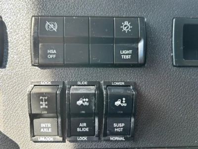 Dashboard switch panel with HSA OFF, LIGHT TEST, and various controls; includes icons for lock, slide, lower, intraxle, air slide, suspension height.