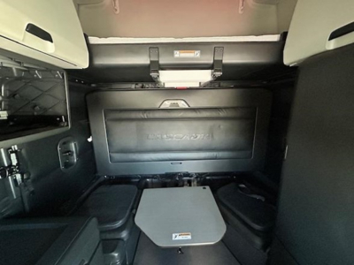 Freightliner Cascadia sleeper cab interior showing storage compartments and a foldable table, with dash area and side panels visible.