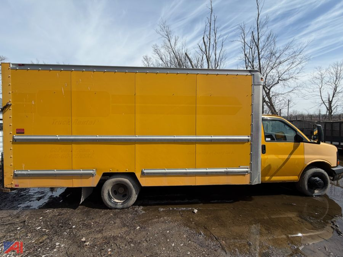 GMC Savana box truck side view showing yellow cargo box with metal trim and rear access doors.