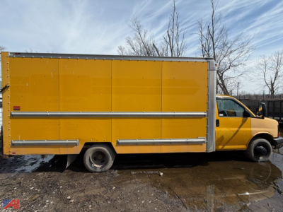 GMC Savana box truck side view showing yellow cargo box with metal trim and rear access doors.