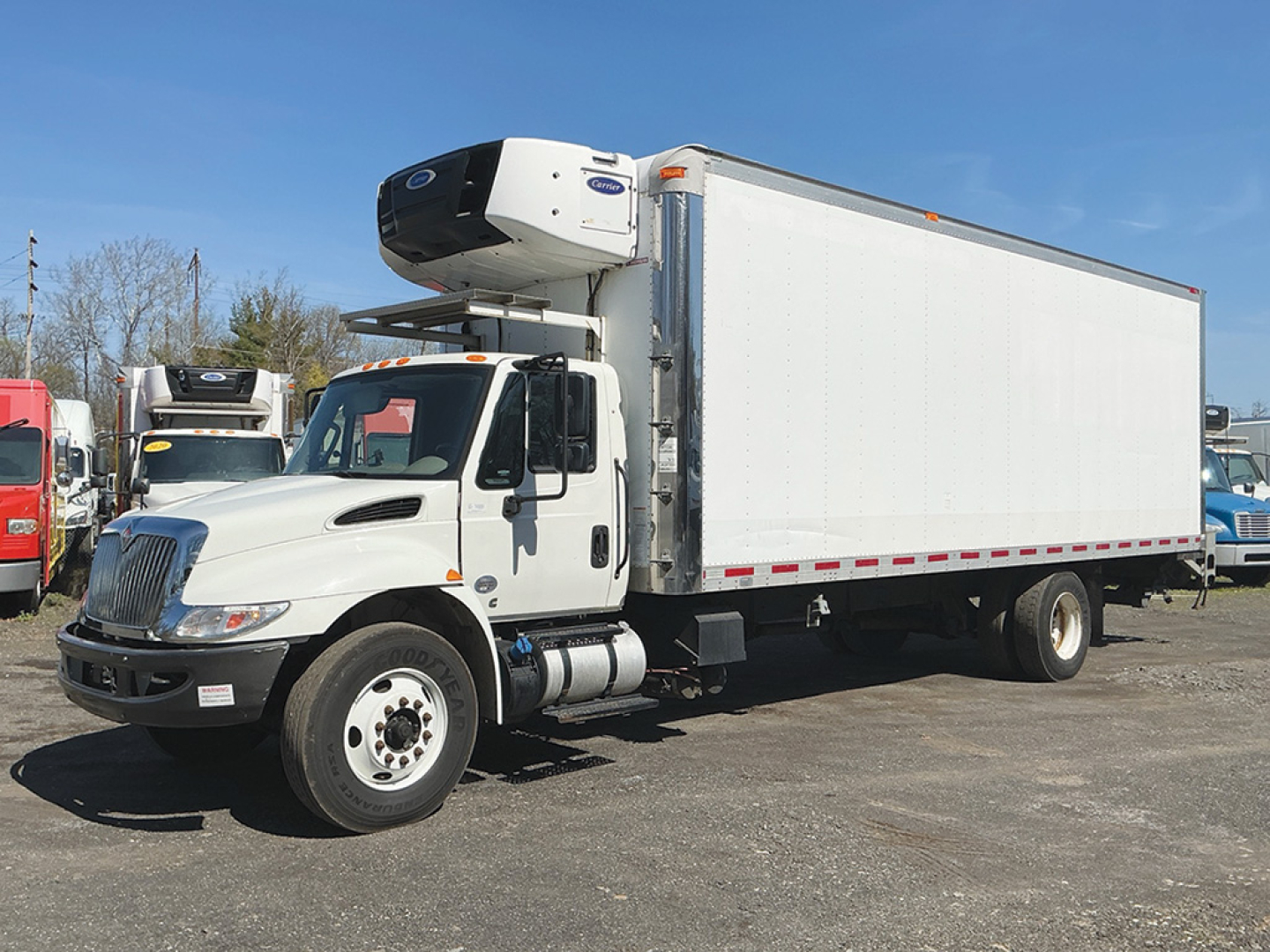International 4300 refrigerated truck with a front-mounted refrigeration unit and white box, side view showing cab and cargo trailer.