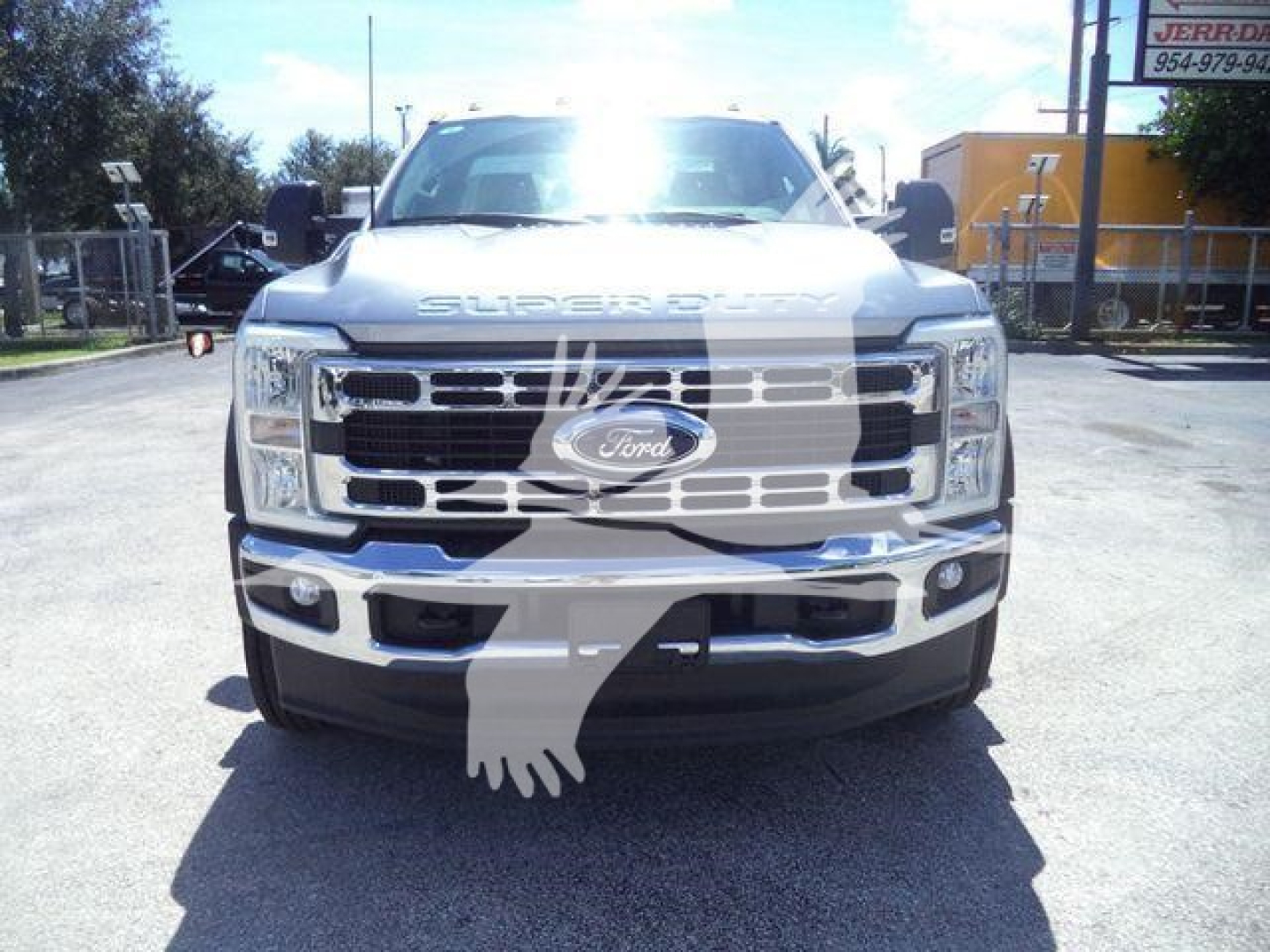Front view of a white Ford Super Duty F-600 series truck with large chrome grille and Ford emblem; visible text on grille and hood includes 'SUPER DUTY' across the top.
