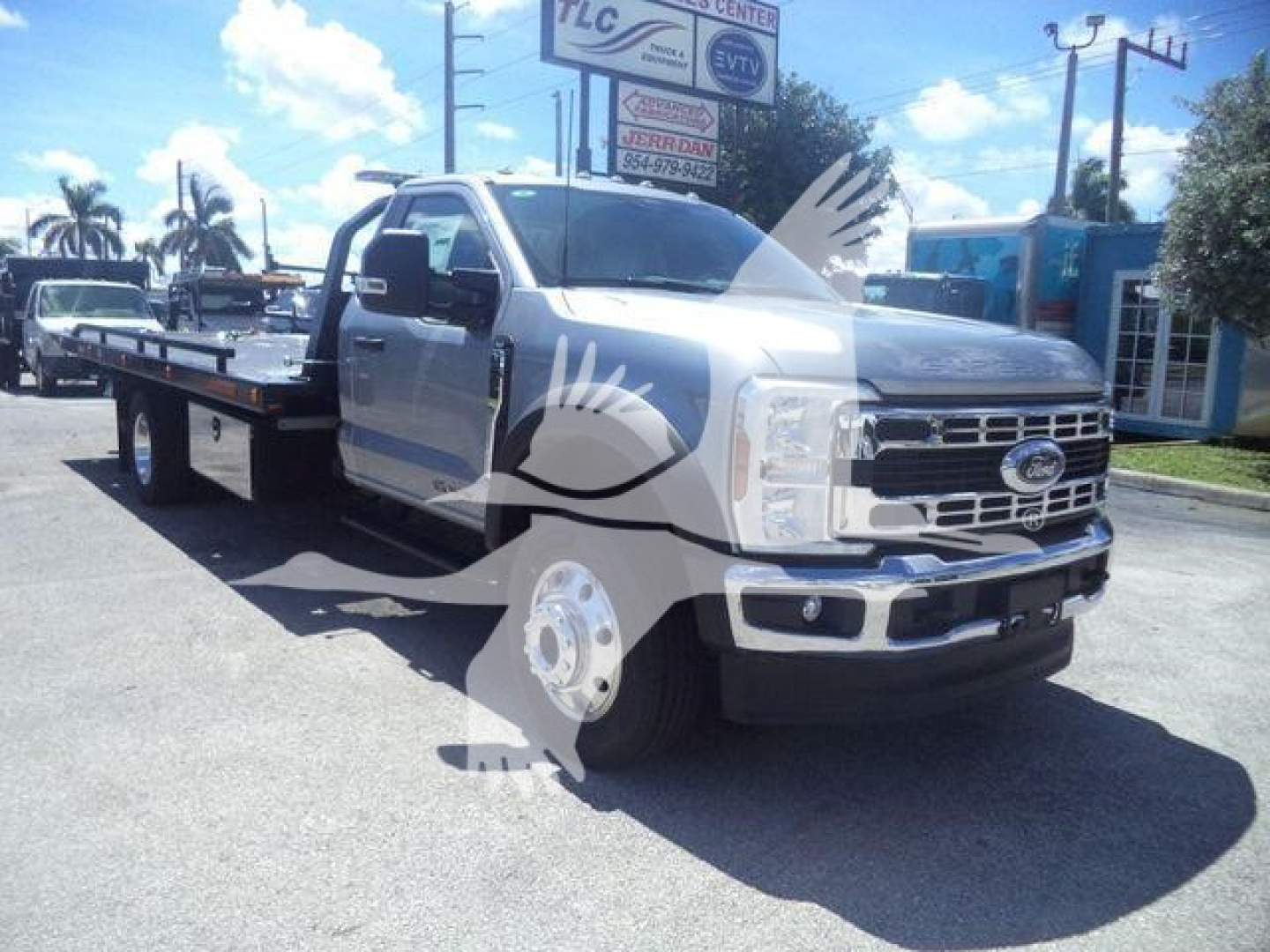 Ford F-600XLT rollback tow truck in a dealership lot with watermark overlay