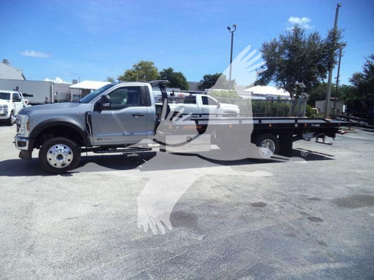 Ford F-600 XLT rollback truck with flatbed and dual rear wheels, side view showing cab and long deck.