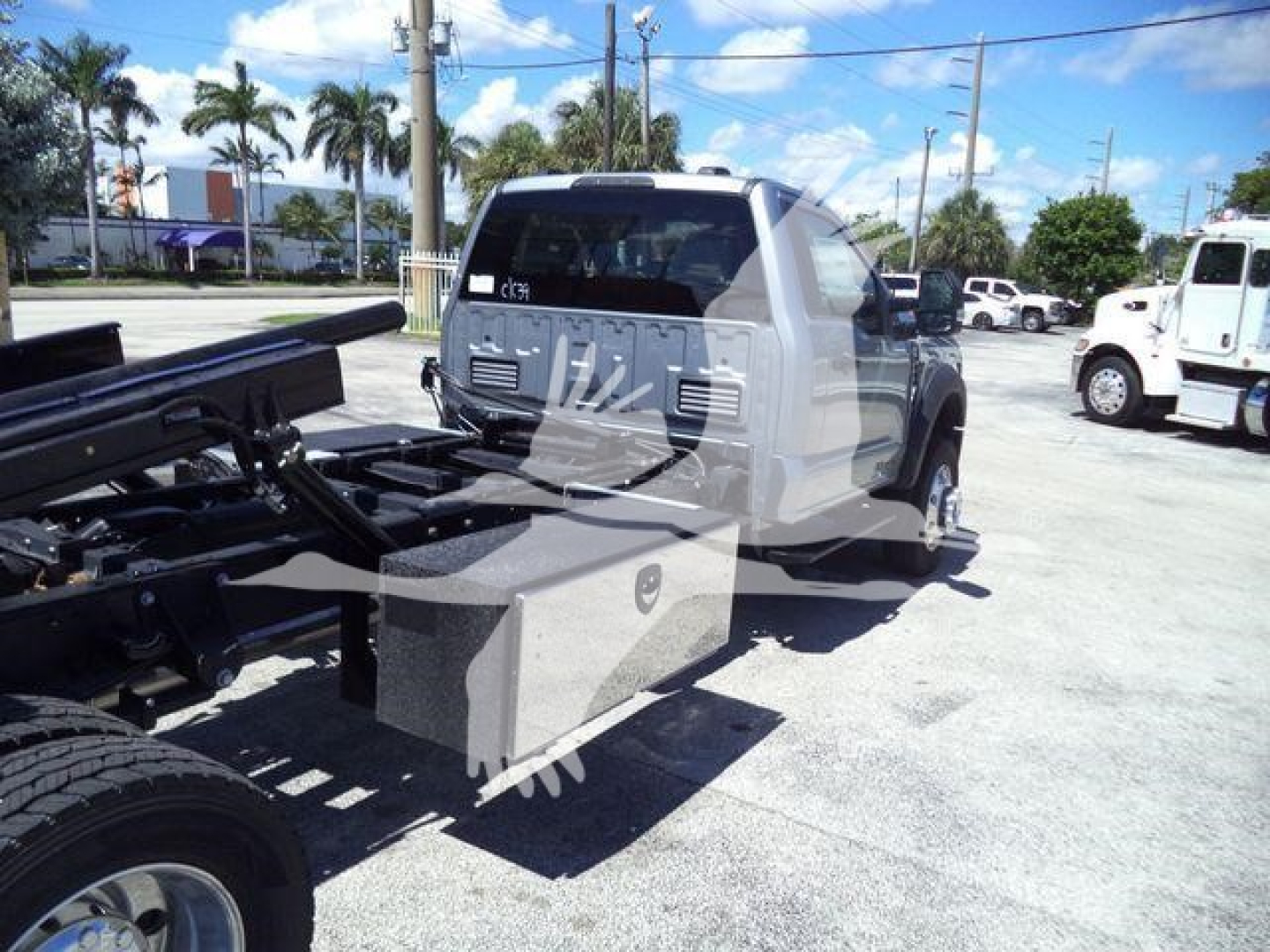 Ford F-Series truck cab chassis in a rollback yard showing chassis frame and service body mounting area.