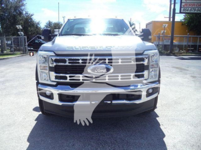 Front view of a white Ford Super Duty F-600 series truck with large chrome grille and Ford emblem; visible text on grille and hood includes 'SUPER DUTY' across the top.