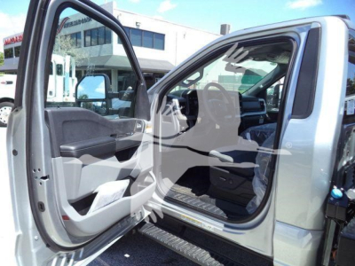 Truck cab interior of a 2024 Ford F-600 XLT showing front door open, gray interior, steering wheel, and dashboard.
