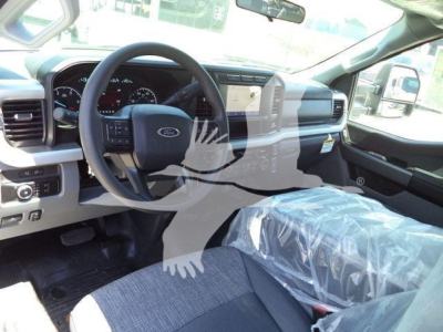 Ford F-600 XLT pickup interior showing steering wheel, dashboard, and front passenger seat with protective plastic cover.