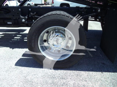 Wheel and suspension area of a 2024 Ford F600 XLT rollback truck showing front wheel and undercarriage components.