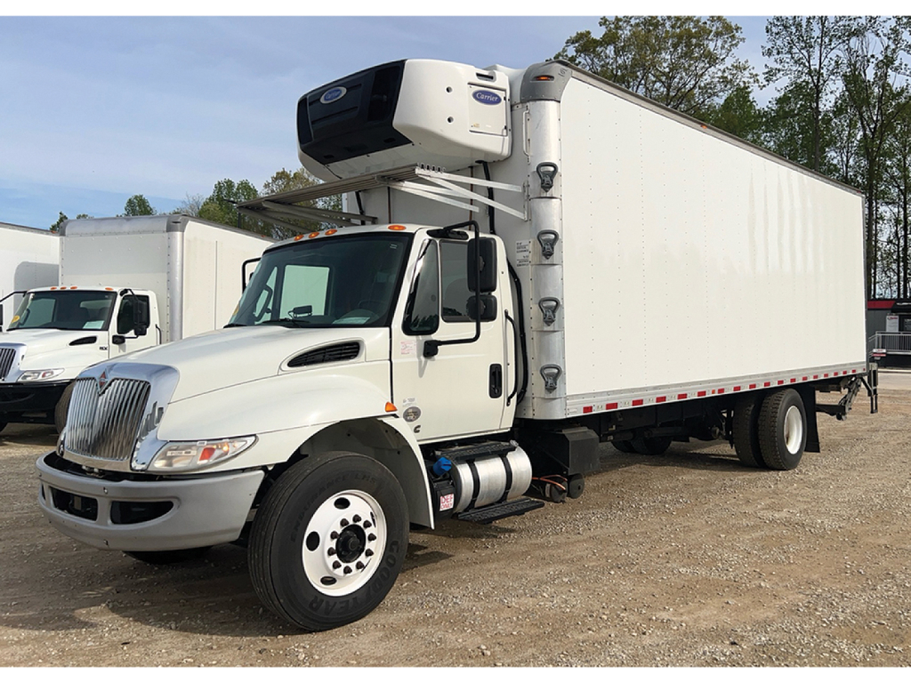 International 4300 refrigerated truck in-service with front-mounted cab and side-draw reefer unit on a white box trailer.