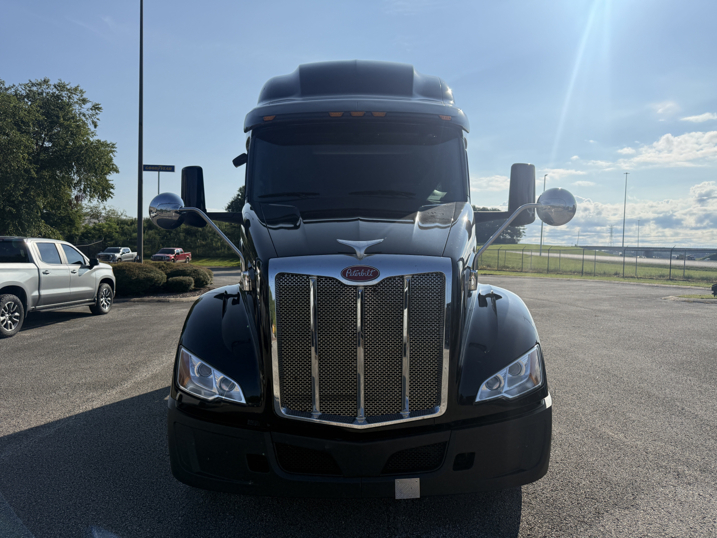 Peterbilt 579 front view showing large chrome grille with Peterbilt emblem, black bumper, side mirrors, and aerodynamic hood.