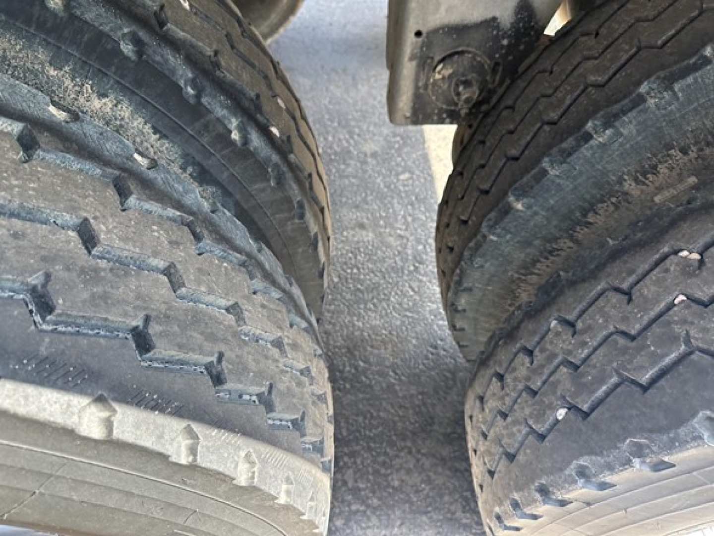 Rear view of a Stoughton grain hopper trailer wheel assembly showing dual tires and suspension components.