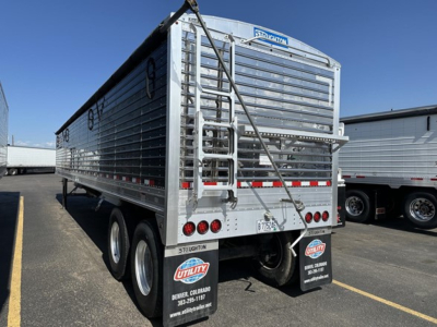 Stoughton grain hopper trailer rear view showing metal corrugated sides, dual rear doors, ladder, and tag lights.