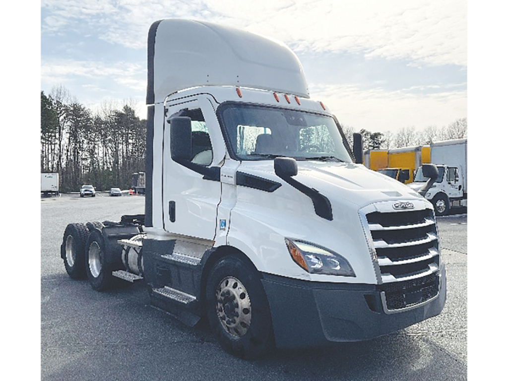 Freightliner Cascadia-116 tractor in a dealership lot showing front grille, cab, and dual rear axles with 6x4 configuration.