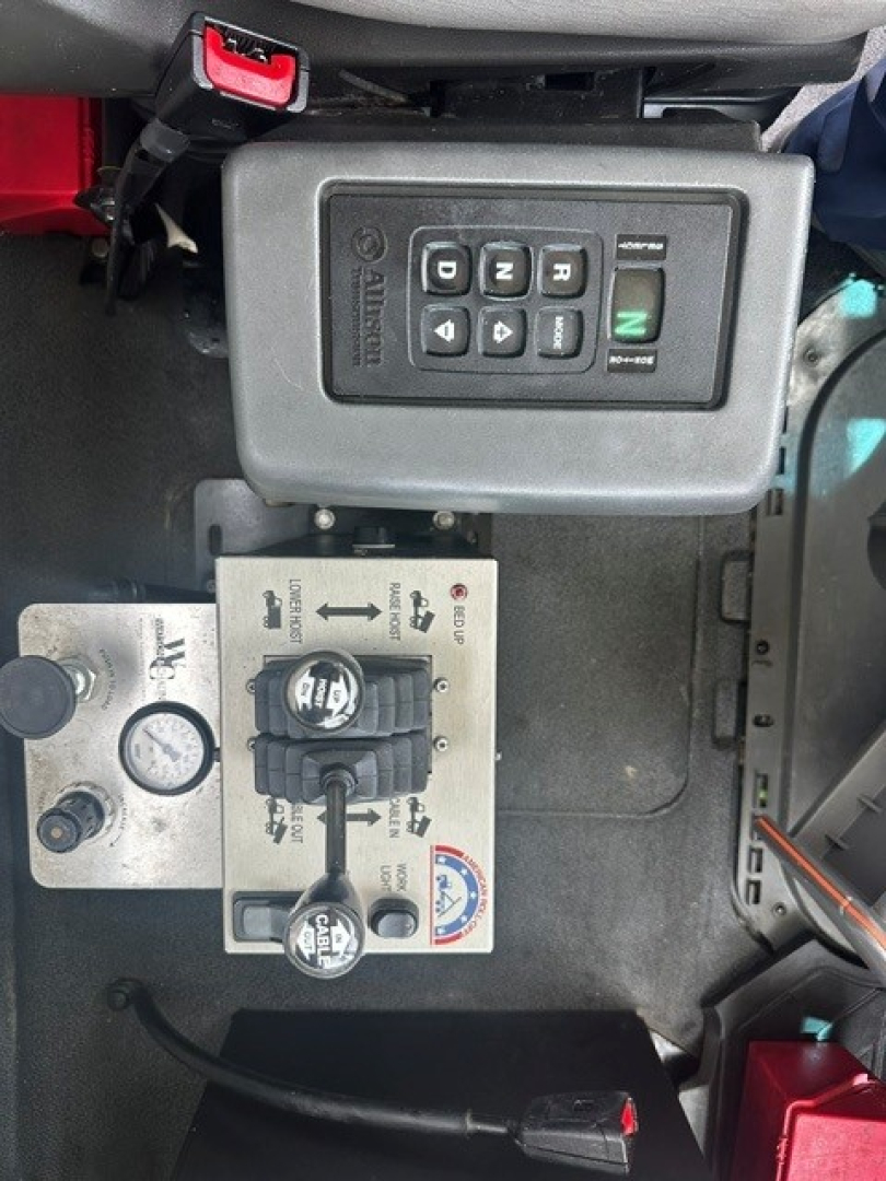 Volvo VHD cab interior showing gear selector with buttons and control switch panel, plus hydraulic levers and gauges.