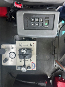 Volvo VHD cab interior showing gear selector with buttons and control switch panel, plus hydraulic levers and gauges.