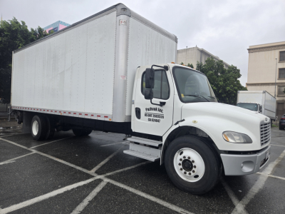 Box truck attached to a Freightliner M2 chassis, white cab with black mirrors, large white box body, VIN 3ALACWFC0KDKN2619 not visible in image but truck appears in parking lot.