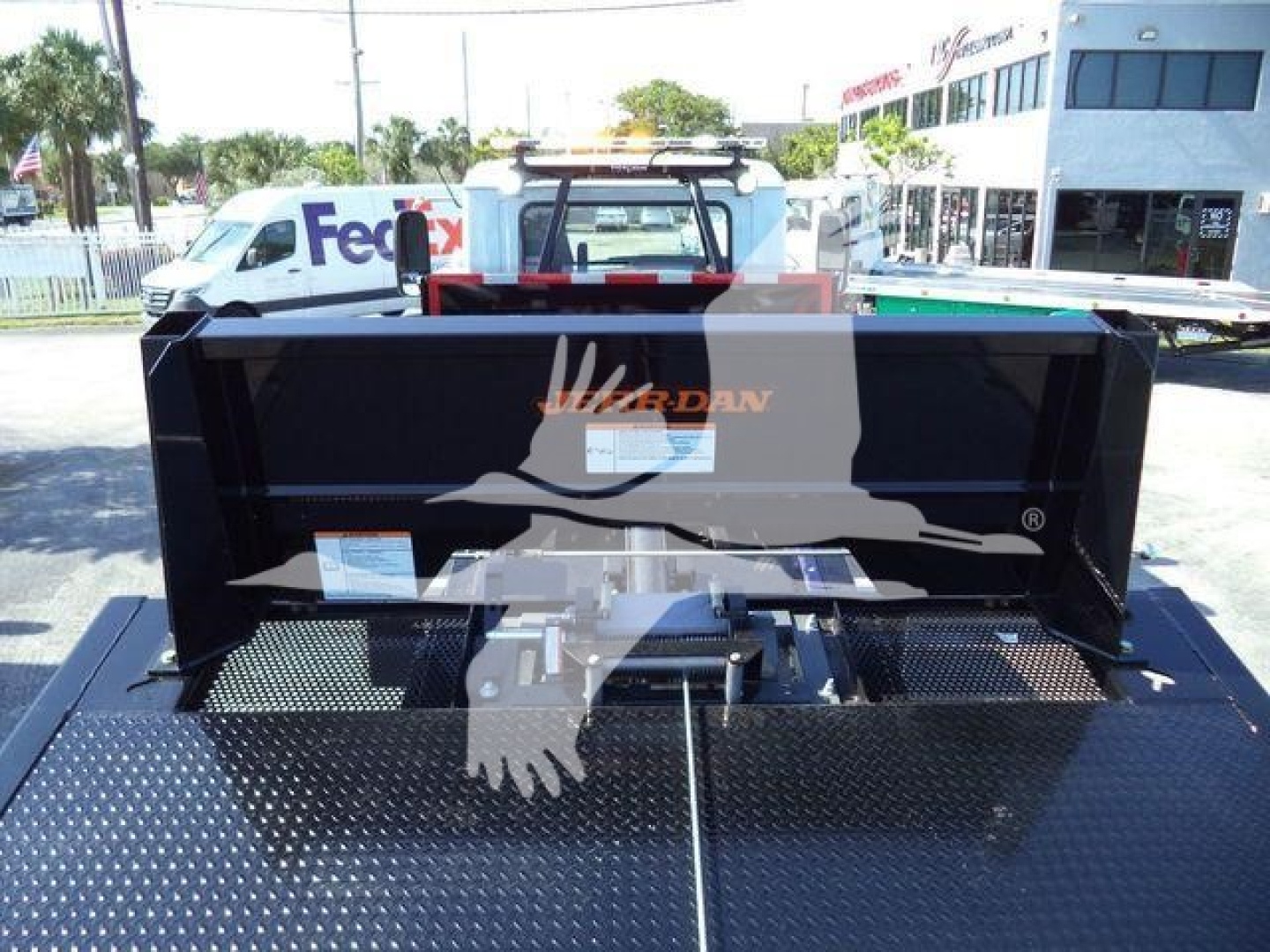 MD6 truck bed showing HD black dump hopper with Diamond plate bed and hitch assembly, Mack logo on tailgate area, in-service equipment image.