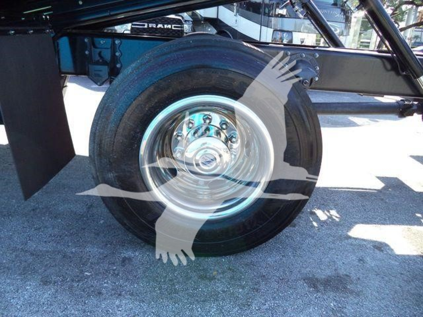MD6 truck undercarriage showing front wheel with chrome hubcap and black tire, part of trailer chassis visible.