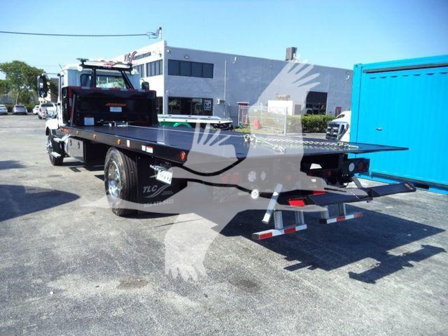 MD6 roller rollback truck flatbed with blue rear container and equipment on bed