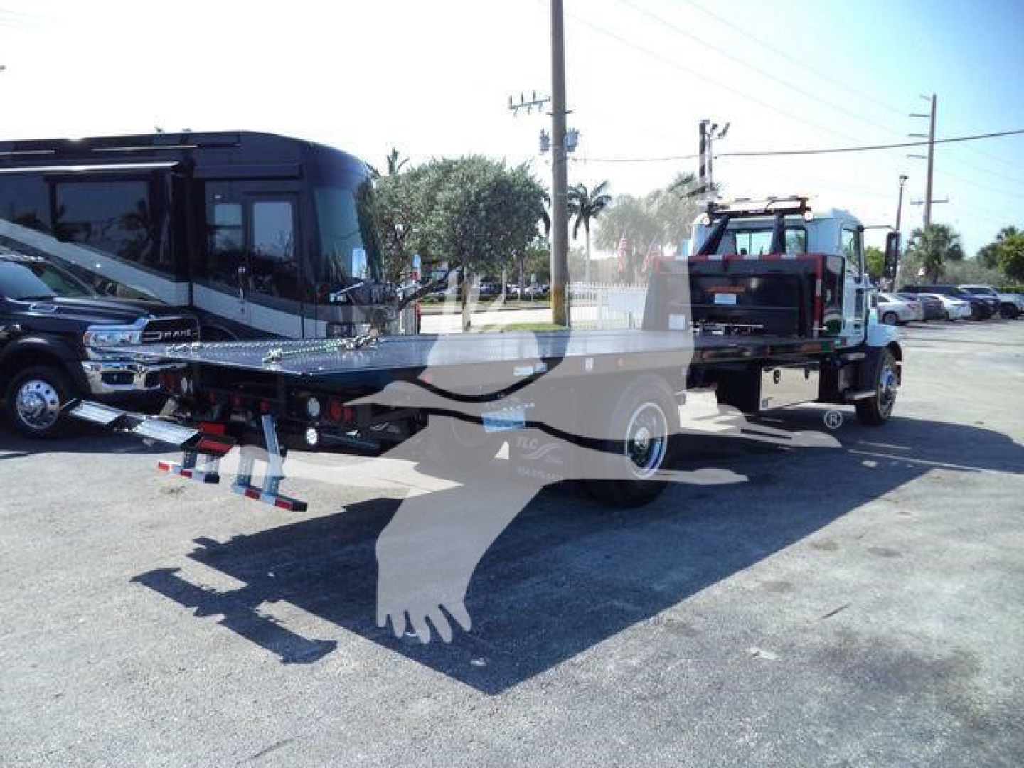 MD6 Mack tow truck with rollback bed and a secondary truck in background; text not clearly legible due to watermark overlay.