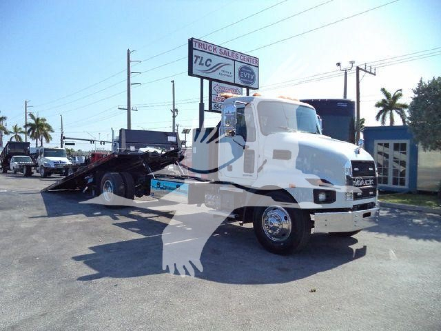 Mack MD6 rollback truck in dealership lot showing MD6 cab and flatbed wrecker equipment