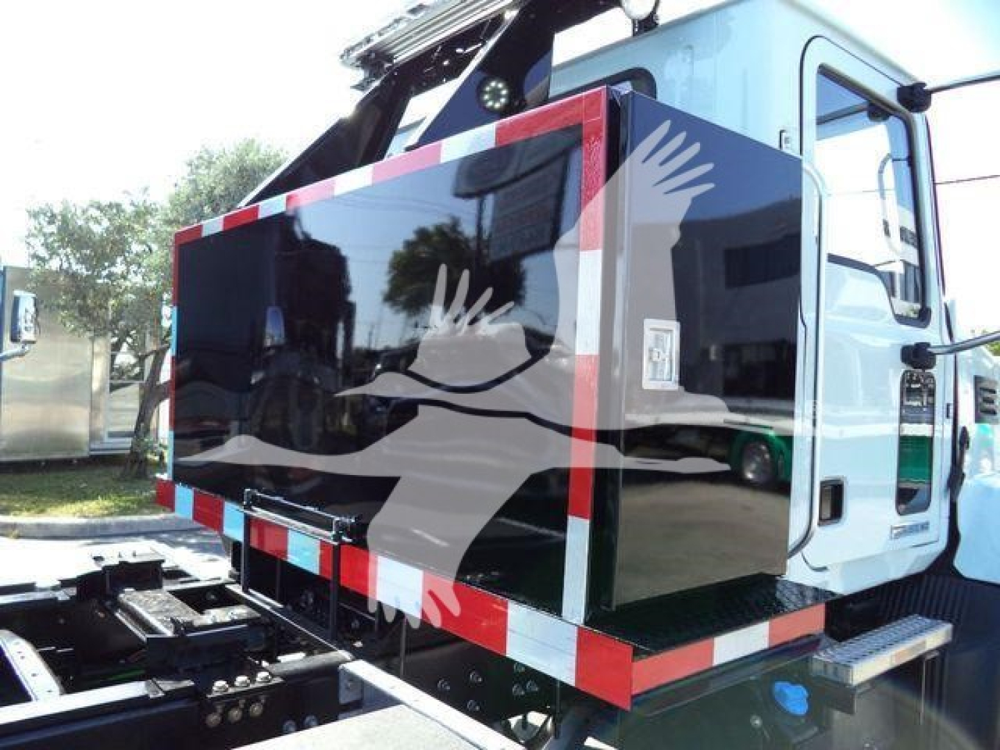MD6 Mack rollback truck cab and rear storage compartment with reflective safety stripes and rear access area visible.