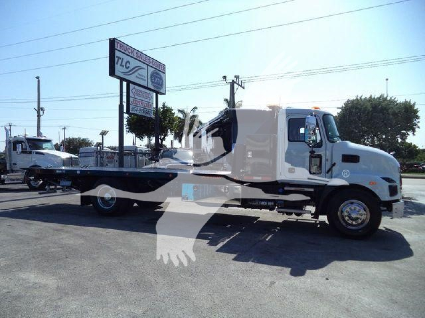 MD6 rollback tow truck showing Mack MD6 chassis with flatbed and white cab, side view