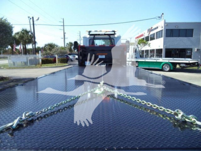 MD6 truck rollback bed with chains on diamond plate and front cab in background
