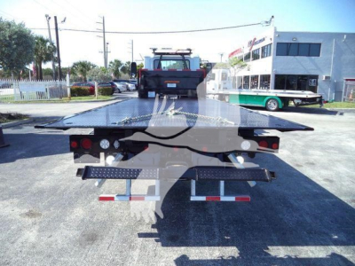 Flatbed tow truck bed on a Mack MD6 chassis showing rear lights and reflectors