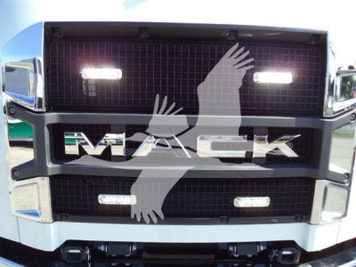 Mack MD6 grille close-up showing illuminated grille lights and large 'MACK' logo across center.