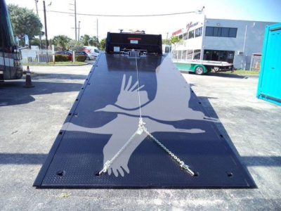 Steel black tow ramp on Mack MD6 with safety chains across the surface, diamond plate texture, and a headboard at the top.