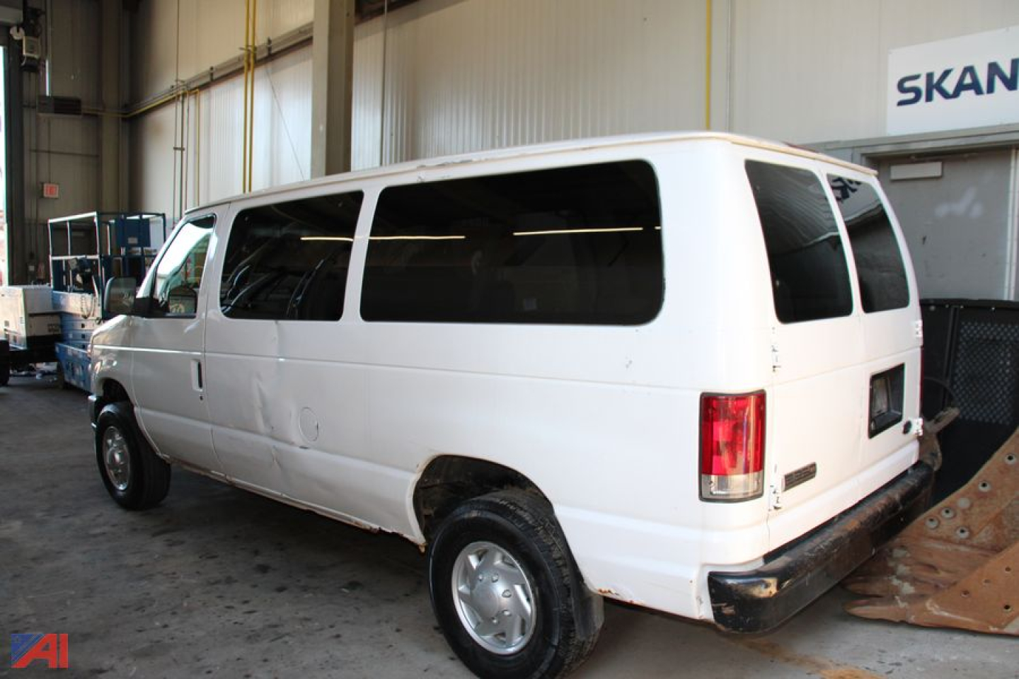 White 2008 Ford E250 cargo van in a warehouse bay, right rear and side view visible with windows and bumper.