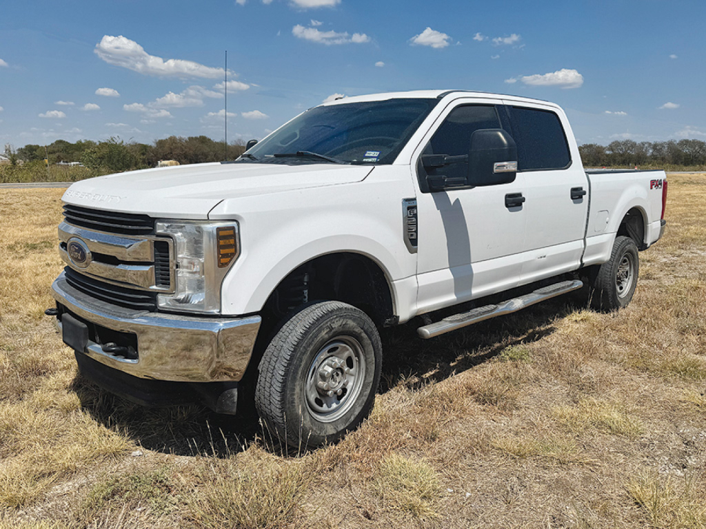 Ford F-250 Super Duty Crew Cab pickup truck in white with chrome bumper, showing side and front view.