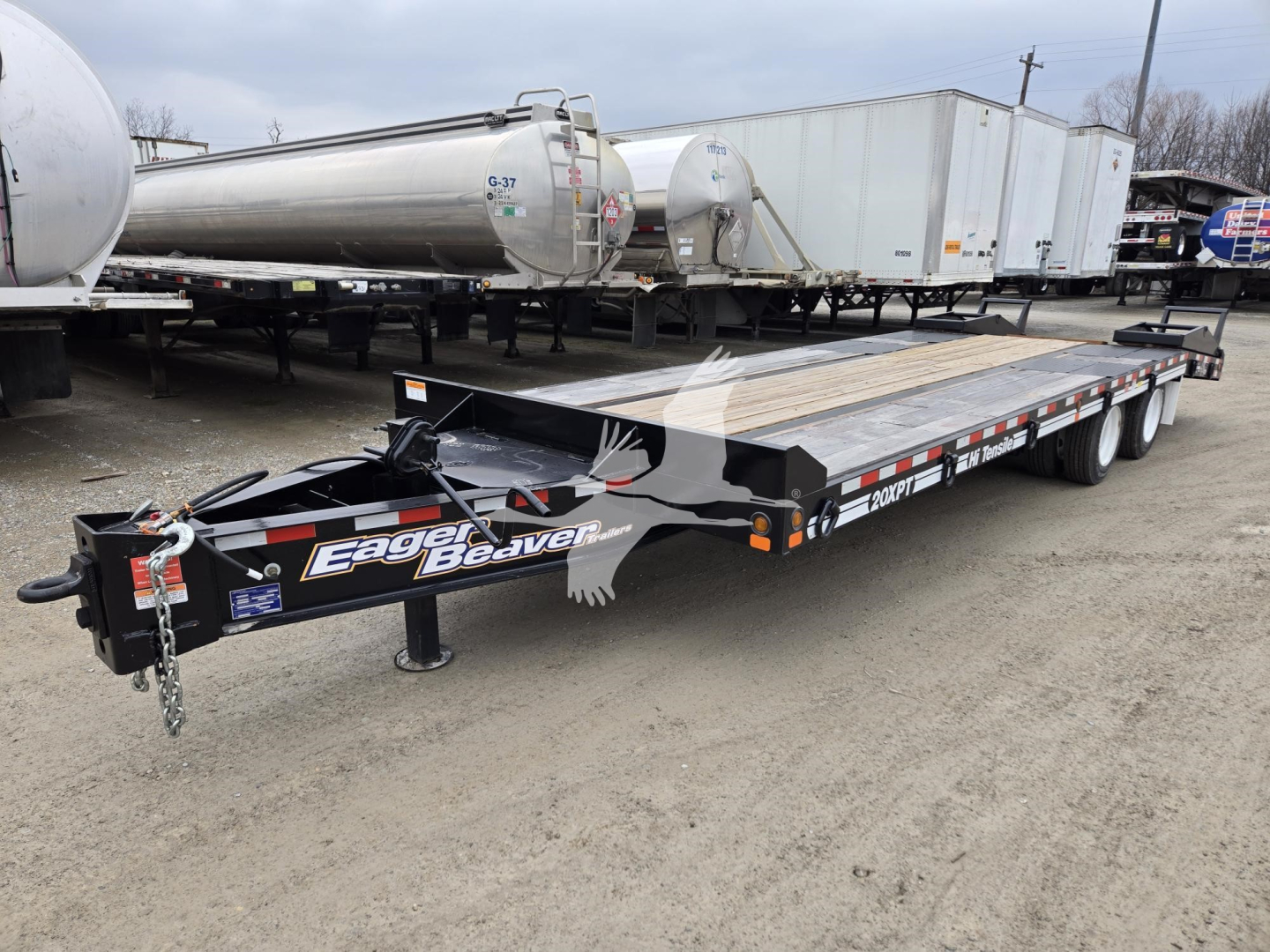 Trailer showing flatbed with black frame and Eager Beaver branding, front tongue and hitch,    in-service components, with attached ramp and a side decal reading Eager Beaver.