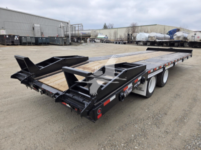 Trailer bed showing heavy-duty flatbed with black frame and dual rear ramps, wooden deck, tandem axle with white wheels, in a storage yard.